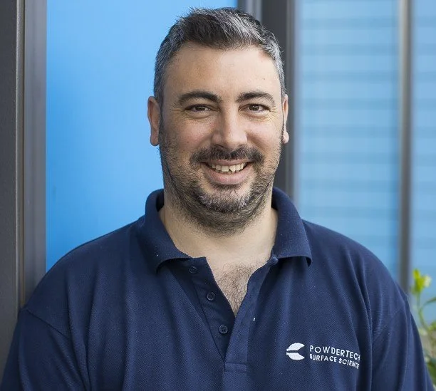 A man in blue t-shit of Powdertech surface Science, outside the company's factory in Bicester, Oxfordshire