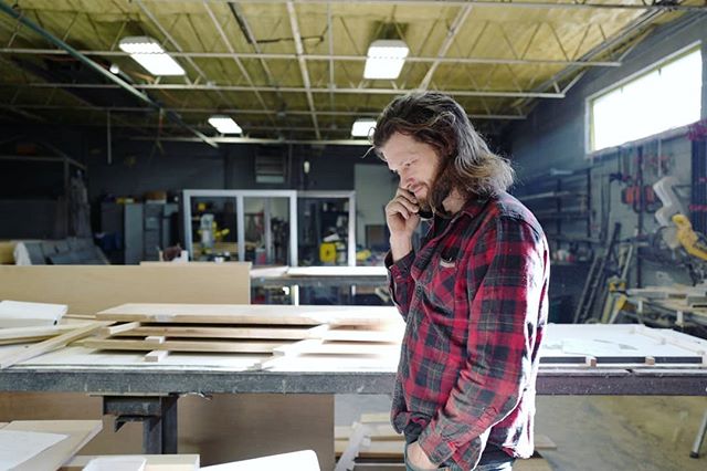 a dashing concrete craftsman in the studio on his phone.
