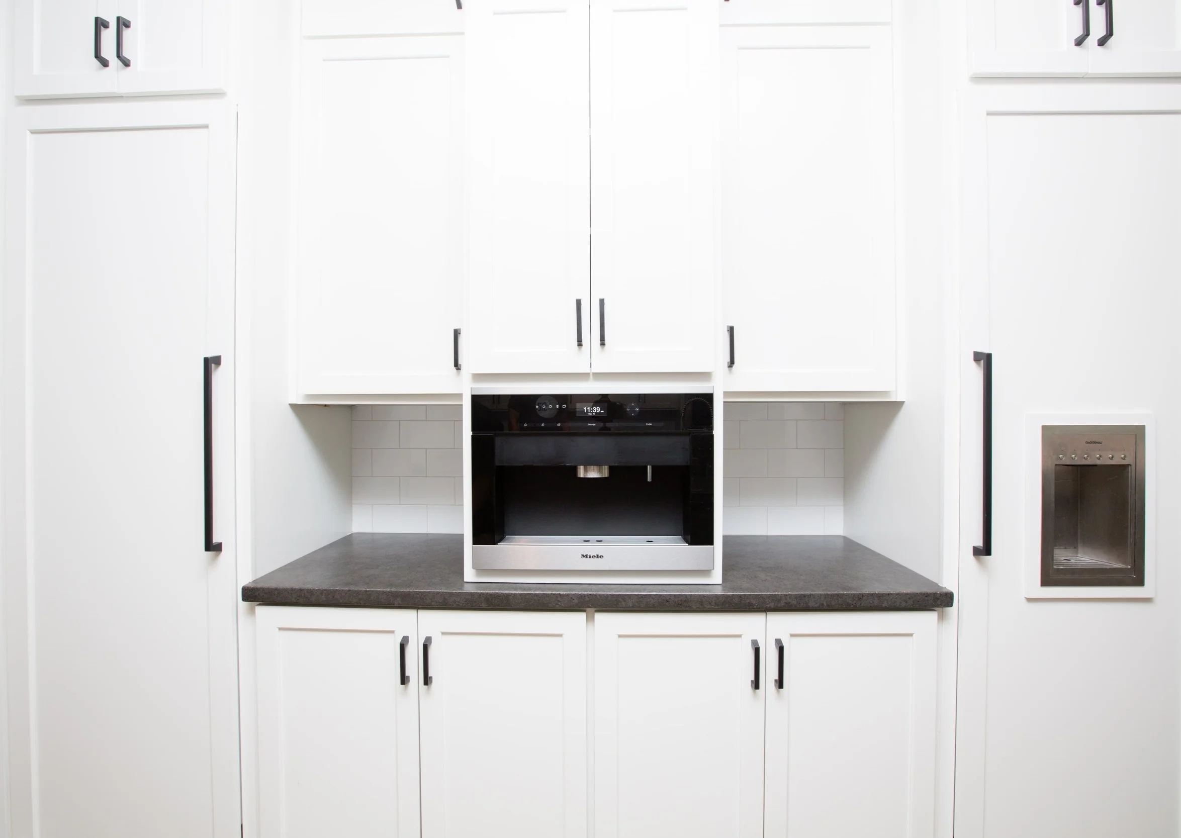 A simple dark and medium grey counter that adds some texture to the drama of a stark white kitchen. #residential