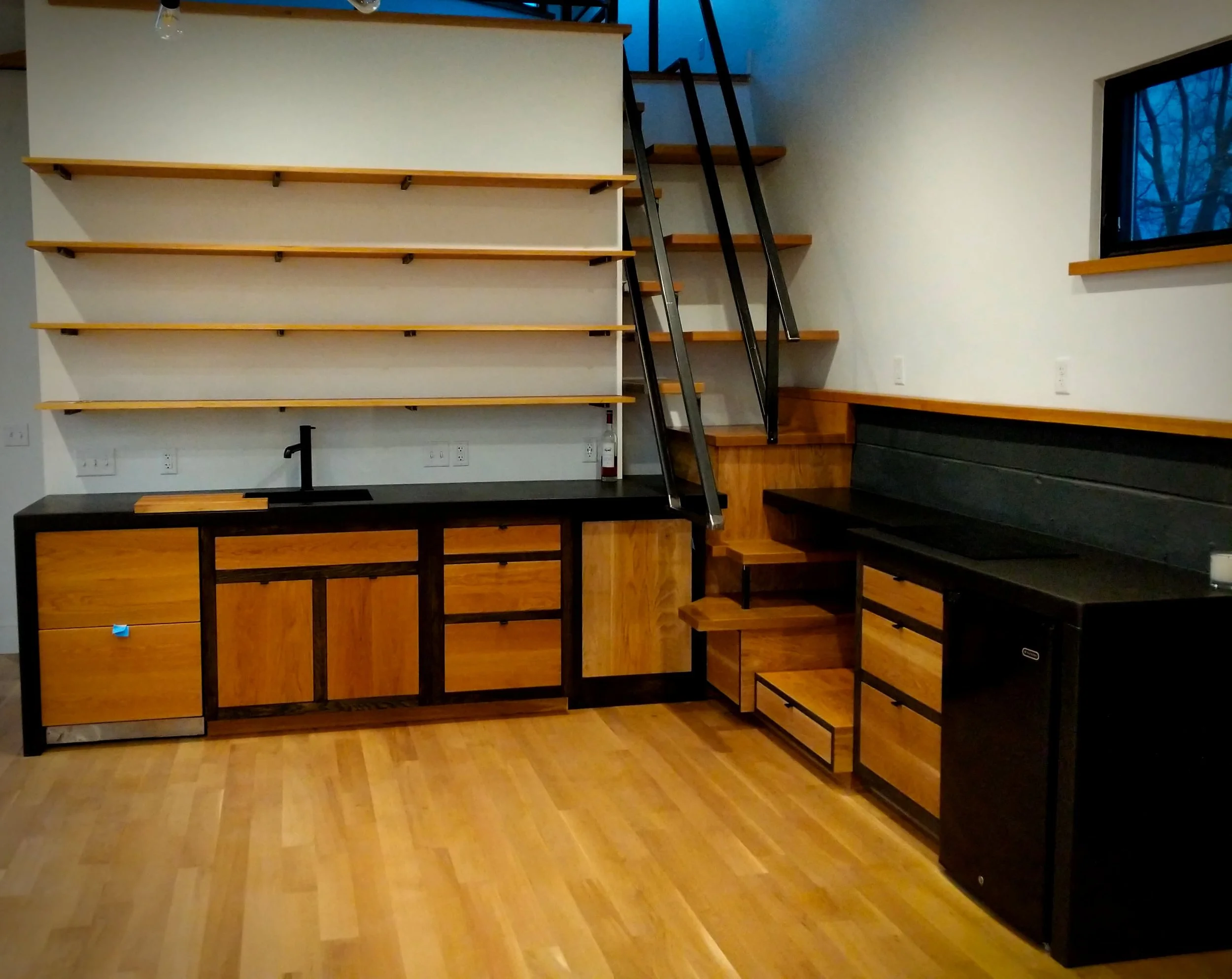 Because of the space constraints of this project, the stairs to the loft area needed to be incorporated into the end of the counter. Though this was a bit of an extreme solution and quite a fabrication challenge, it ended up working quite well. #residential