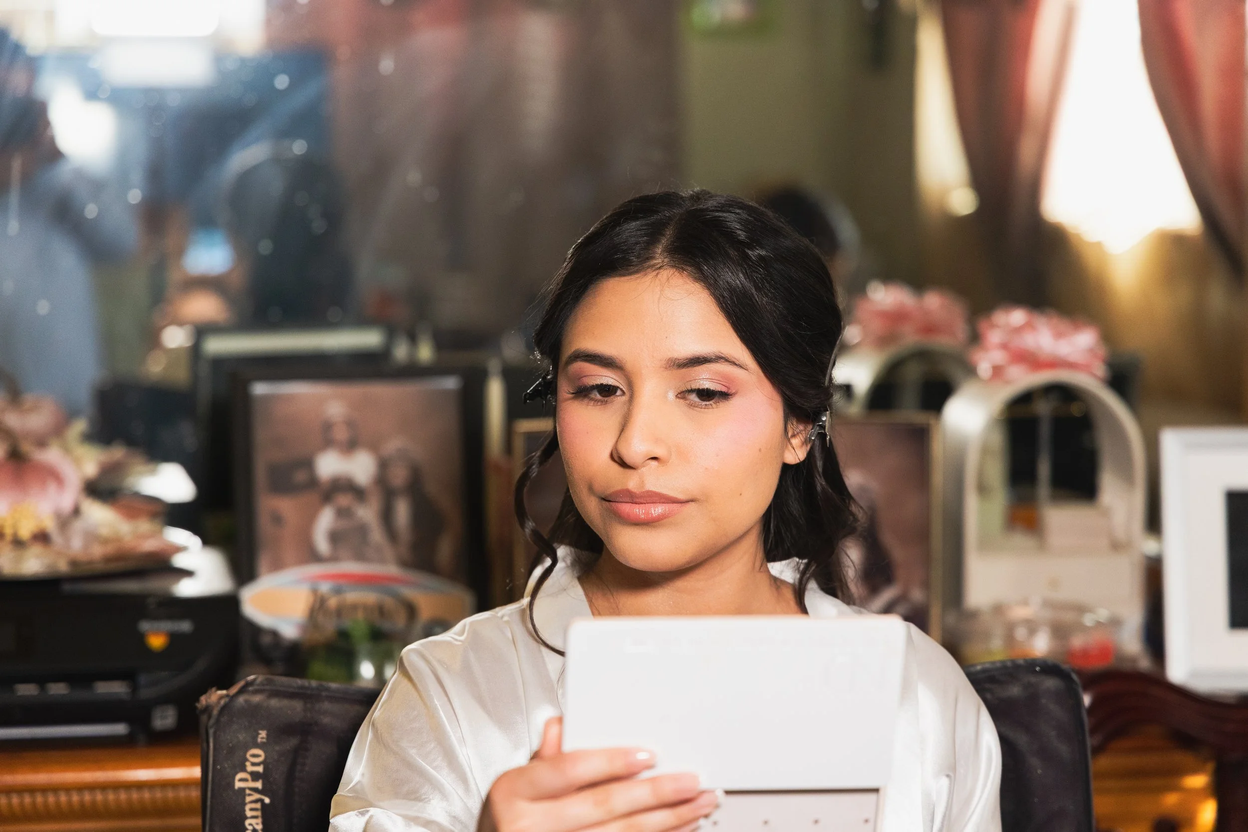 Emily checks her make up in the mirror