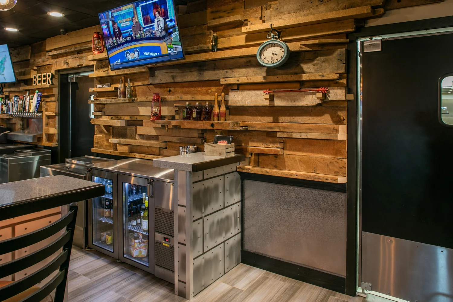 The design honors the family’s storied business history. The new owner recalls helping out as soon as he was old enough to stand on crates behind the counter. A new feature wall behind the bar is finished with historic wood and stone that was salvaged from a downtown church after tornado damage earlier that year.