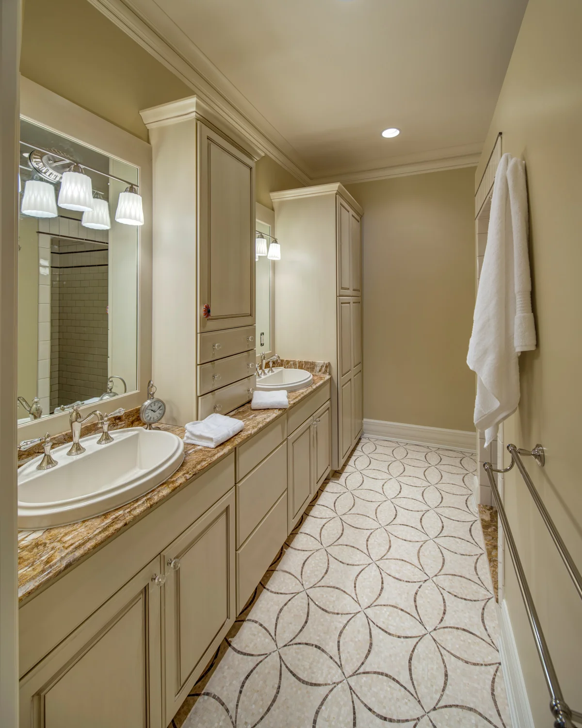 A natural marble mosaic is tiled in an artfully executed pattern in the dry areas of the bathroom, while coordinating durable and slip-resistant ceramic tile was used in the shower.