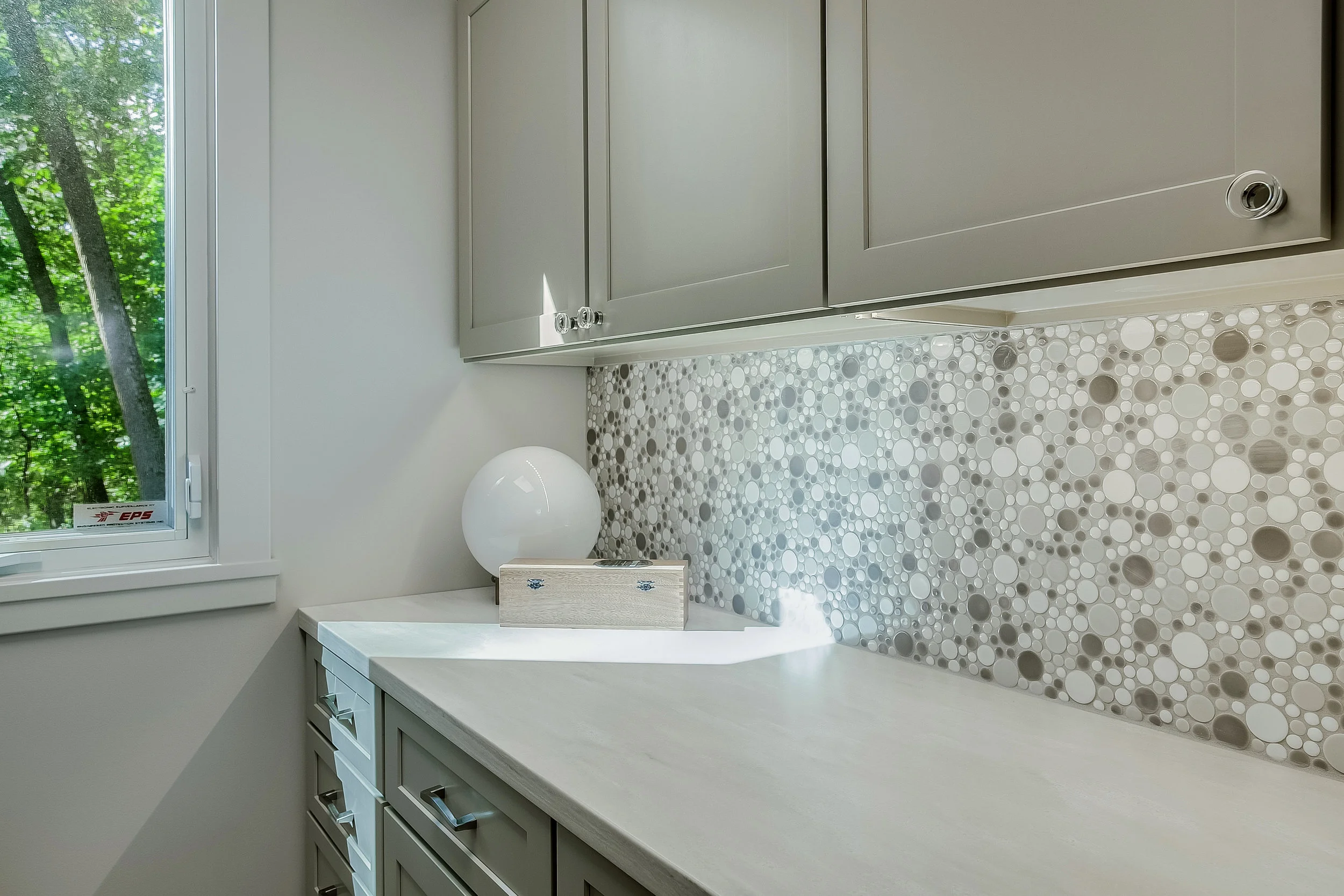 The fun tile in the laundry room reminds us of bubbles - perfect for the tasks at hand in this sunny, updated space. Though short on square footage, the glass hardware (Emtek) and color pallet bring the space to life with interesting detail.