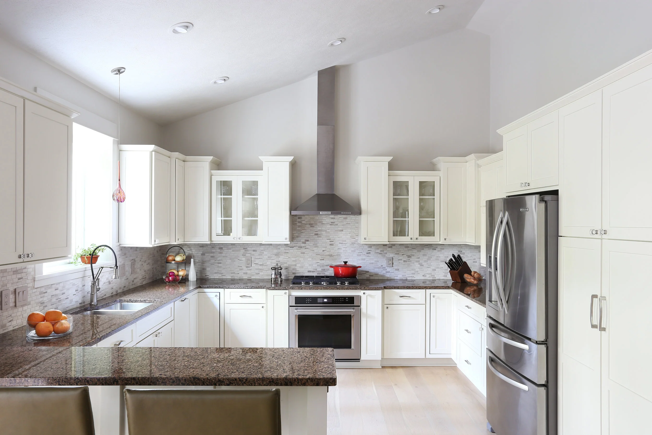 The transformation of this once dark, overwrought kitchen is stunning. The overly-adorned cherry cabinets are now clean and fresh with shaker doors and simple crown, all in a crisp linen white. This kitchen gets lots of use, and is now the creative space the home chef always wanted.