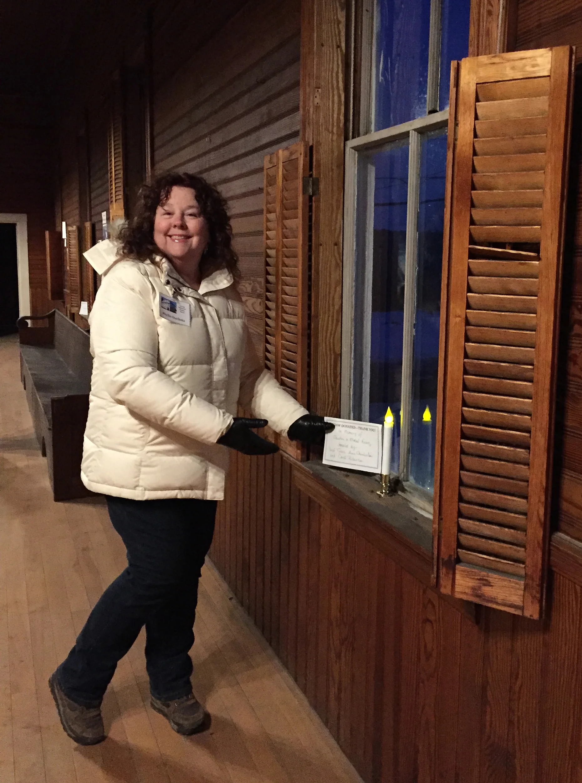 Phyllis Ouellette places one of the window donation signs during the Open House night.
