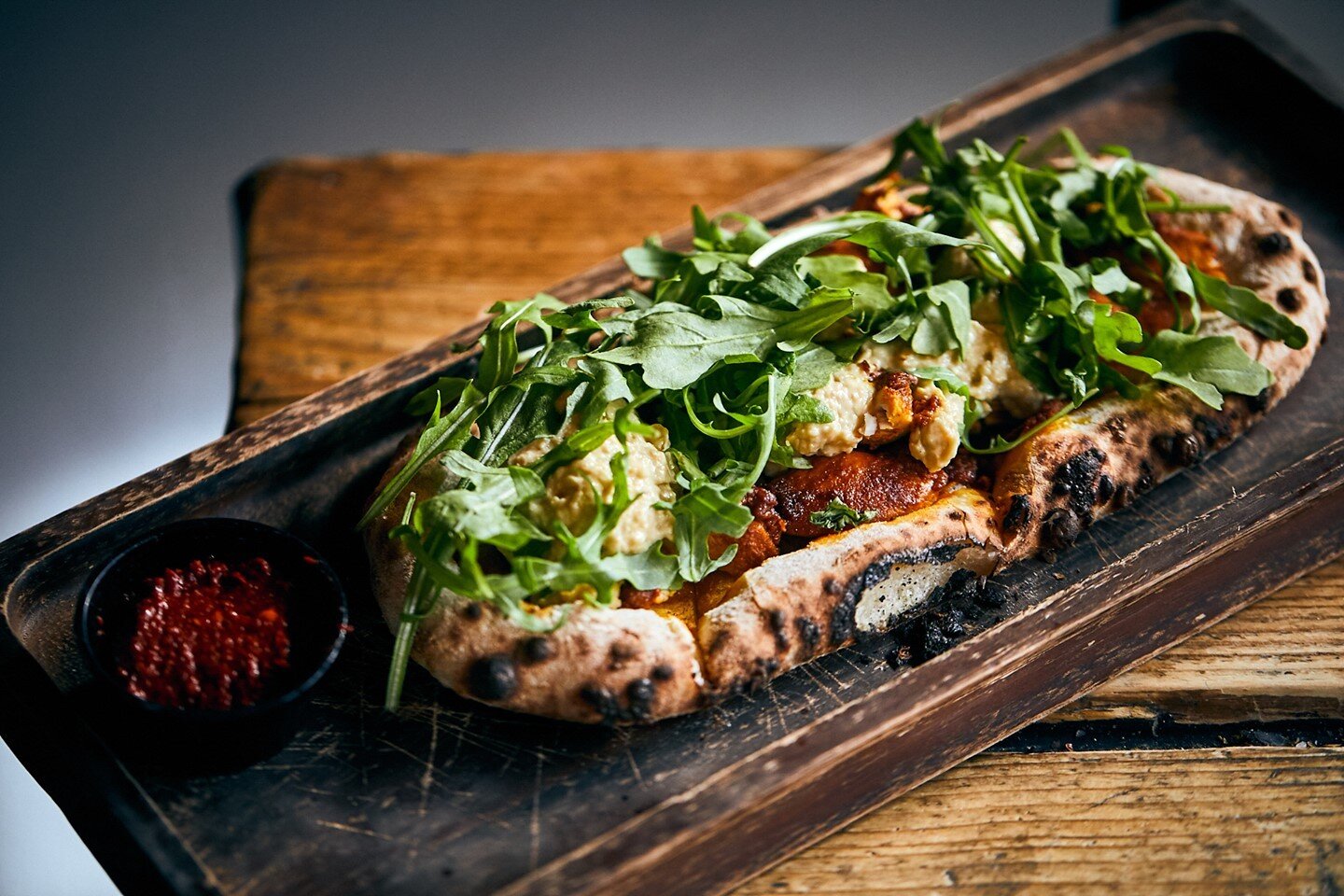 A Flatbread Fav, served warm &amp; toasty from our Woodstone oven. Perfect this grey Wednesday.⁠
⁠
Moroccan Chicken, Hummus, Rose Harissa &amp; Rocket⁠
⁠
Book your table or order online via #LinkInBio. We're open from 4pm. 💛⁠
⁠
⁠
#thincrust #gourmet