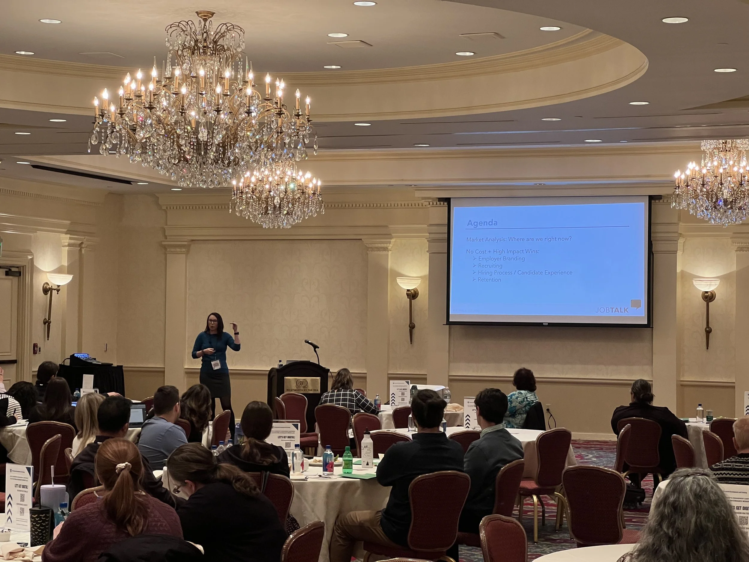 Woman speaking to a crowd about recruiting and retention