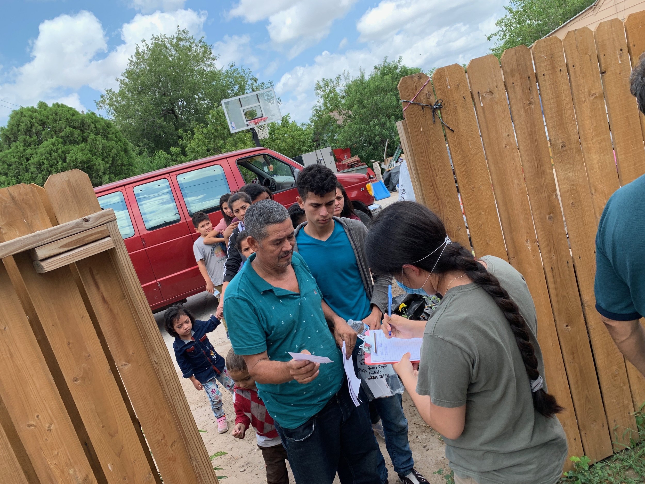 Refugees forming a line to show their documents given by ICE in order to call their relatives for a bus or plane ticket.