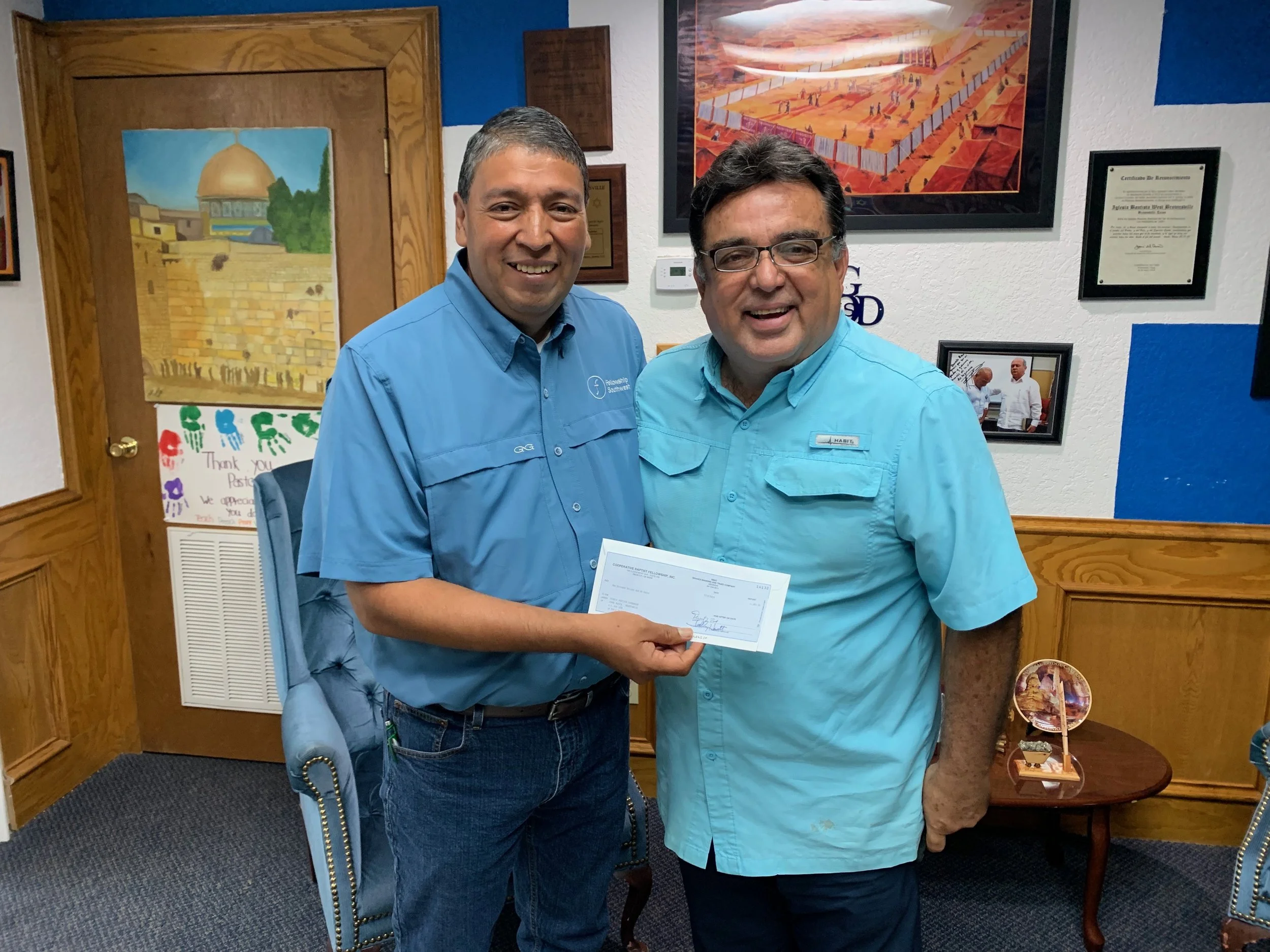 Jorge Zapata (left) of CBF Texas/Fellowship Southwest, presents a check for $1,000 to Rogelio Perez, pastor of Iglesia Bautista Capernaum in Brownsville, Texas. Twice a week, the congregation feeds asylum seekers on the border bridge between Brownsville and Matamoros, Mexico.