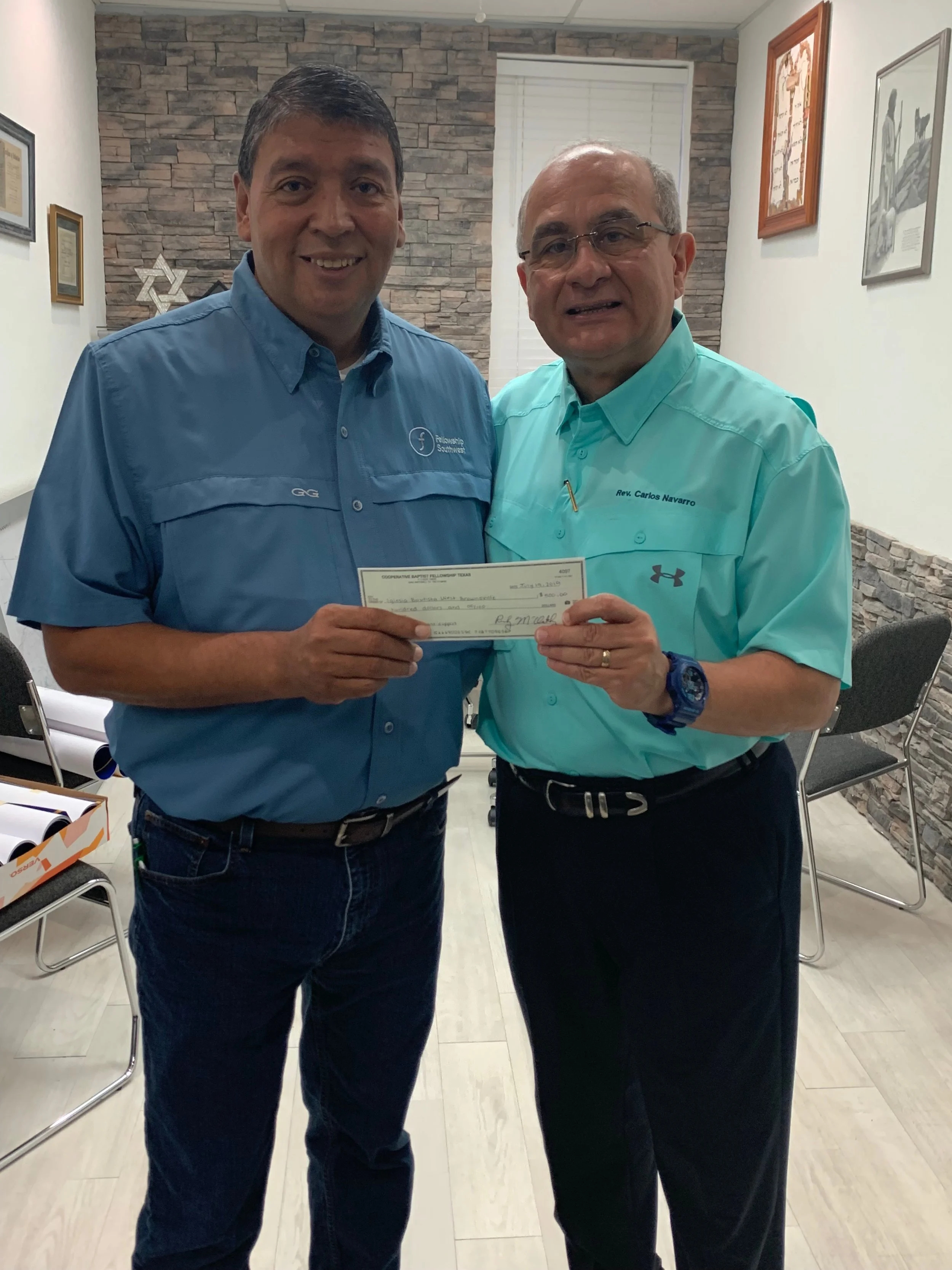 Carlos Navarro, (right) pastor of Iglesia Bautista West Brownsville in Brownsville, Texas, receives $5,000 for the church’s ministry to asylum seekers from Jorge Zapata of CBF Texas/Fellowship Southwest. The congregation shelters 60 to 70 refugees per day in its facilities.