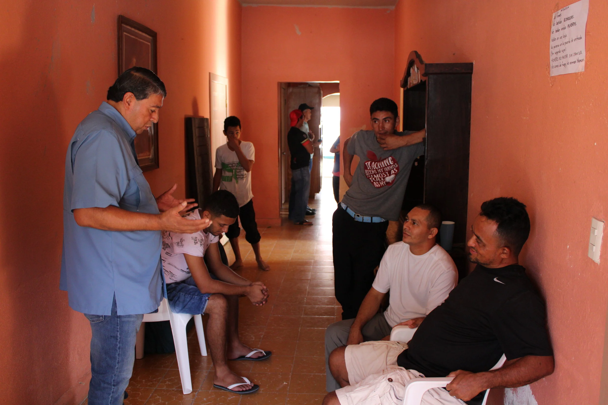 Jorge Zapata, praying with refugees in a shelter operated by Lorenzo Ortiz
