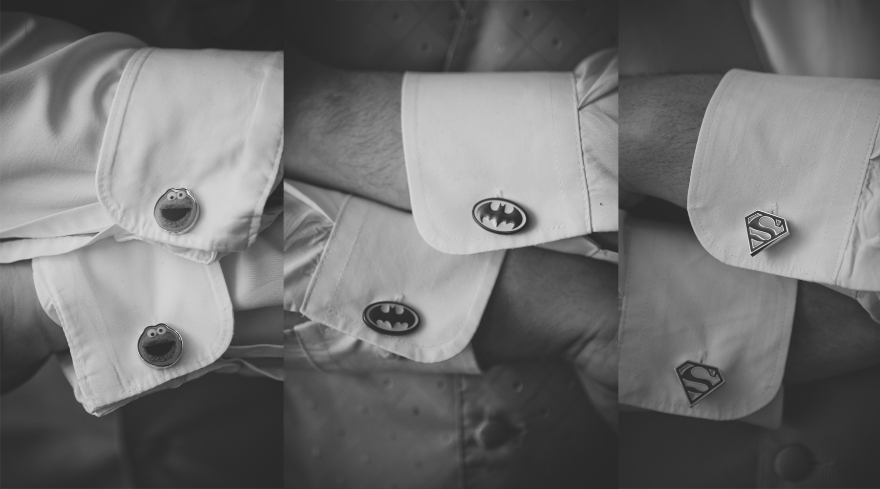Close-up of a person wearing a white shirt with superhero and comic character cufflinks: Elmo, Batman, and Superman logos, displayed on their shirt cuffs.