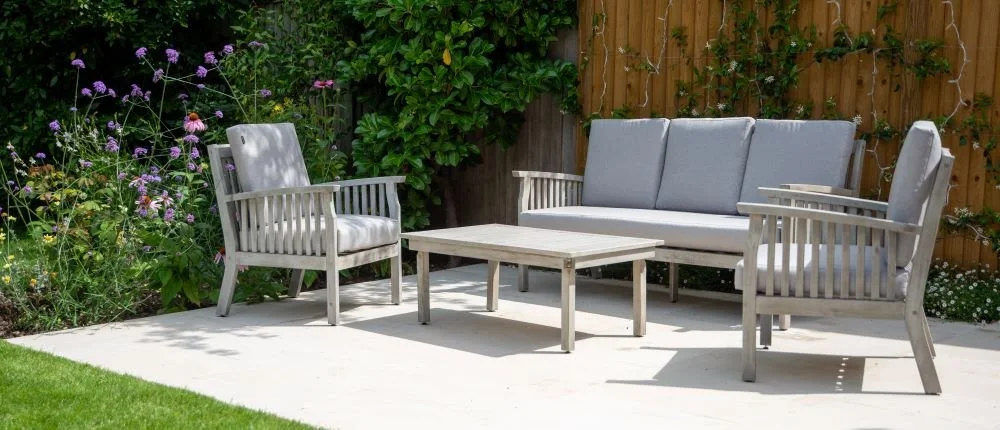 Outdoor sofa and armchairs on a stone terrace beside a flower border in a Wimbledon garden

A relaxed outdoor seating area with sofa, armchairs and coffee table on the stone terrace, positioned beside the border of echinacea and verbena for a garden 