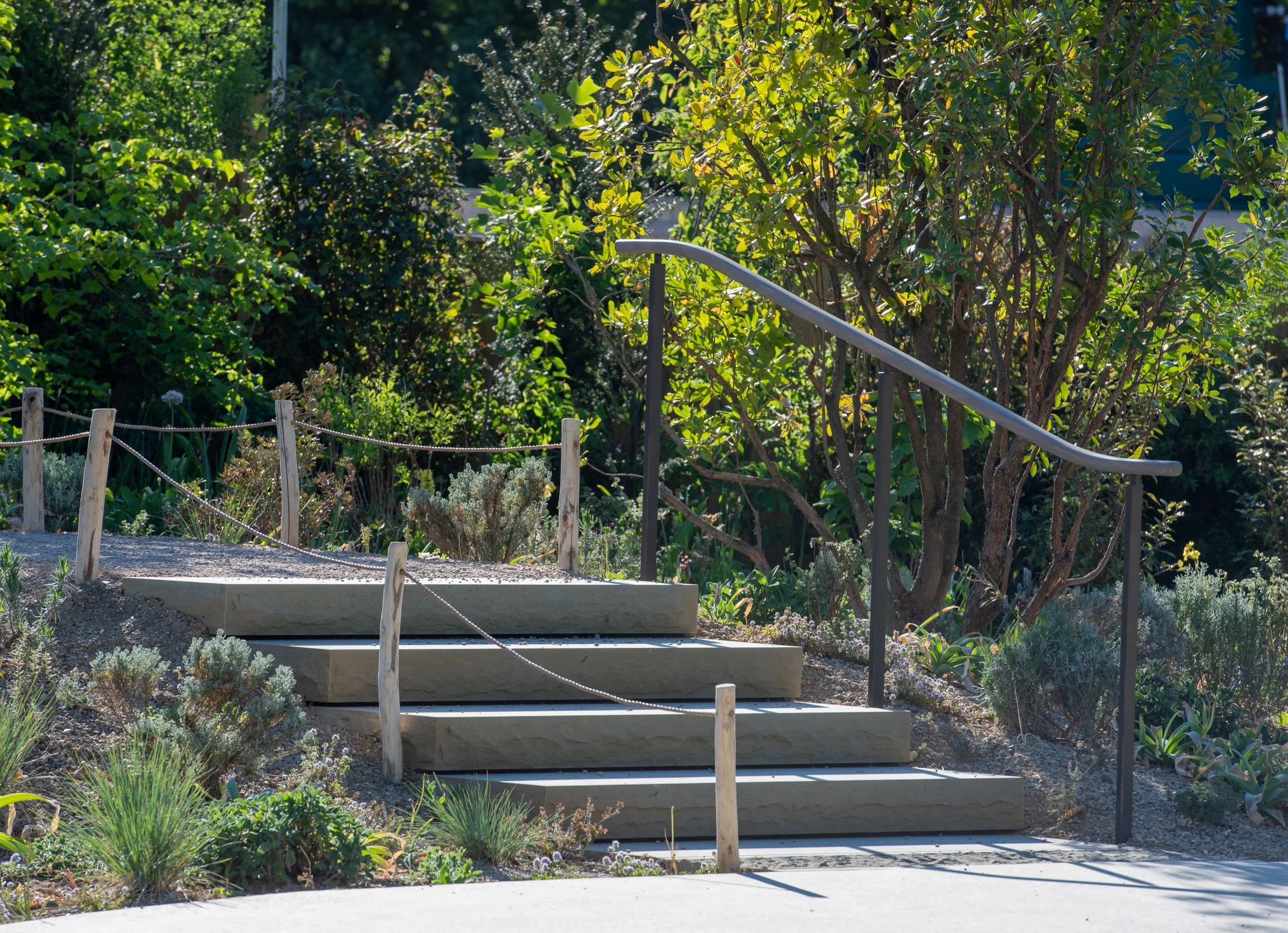 Sandstone steps with a curved metal handrail in the Queen Elizabeth II Garden