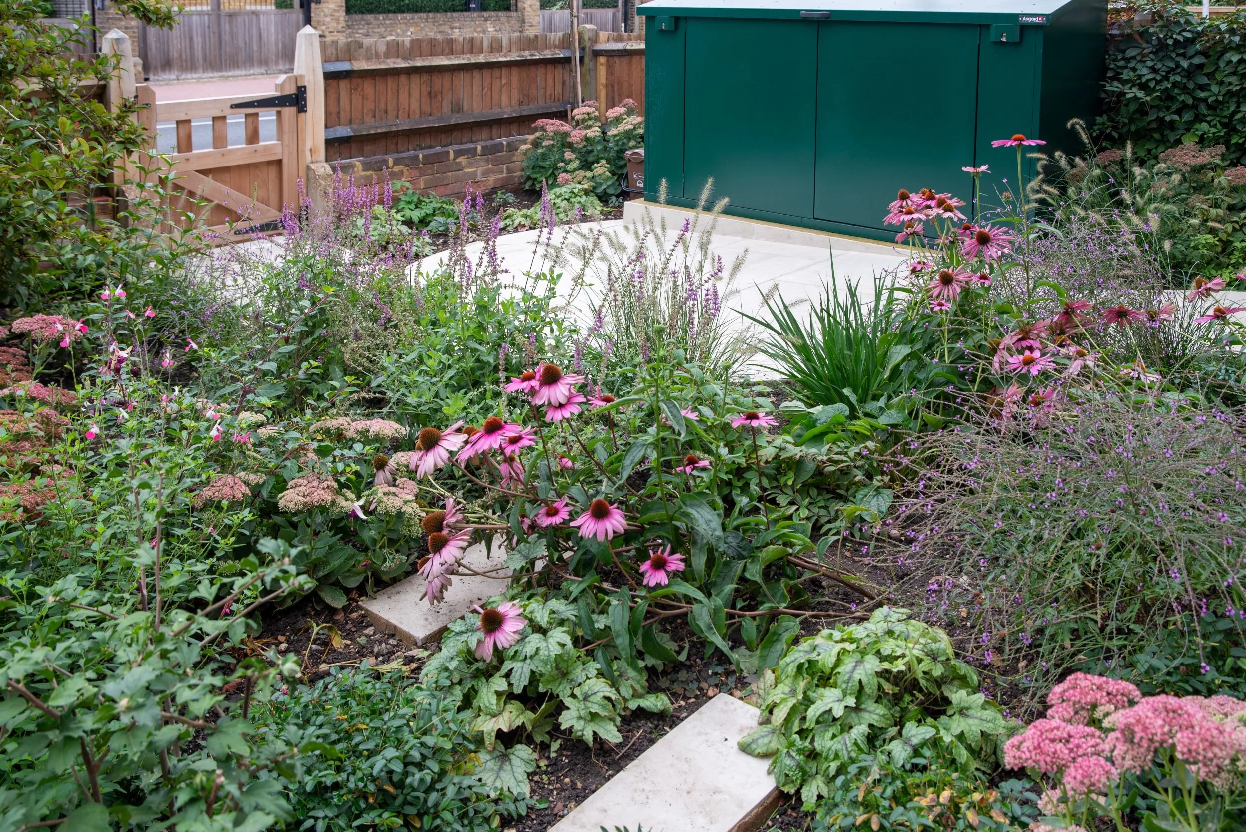 Curving sandstone path leading from a wooden gate to a green front door. Designed by JaneShanksterGardenDesign.co.uk

The new curving sandstone path guides visitors from the timber entrance gate to the home's green front door, flanked by grasses and 