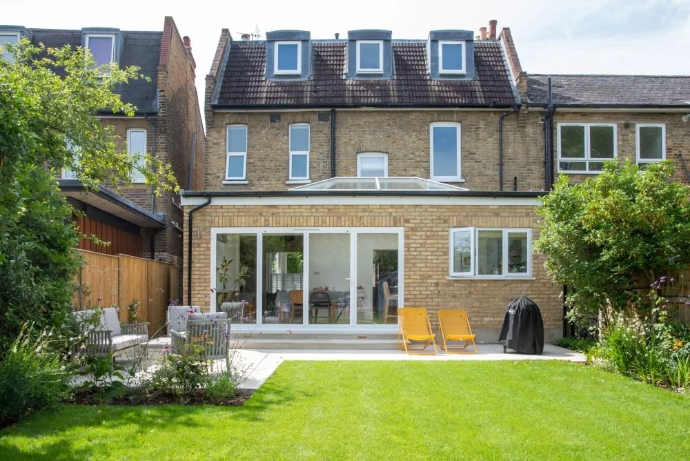Rear view of an Edwardian house and glass extension overlooking a Wimbledon family garden

The rear of the Edwardian house, with its glazed extension opening onto the new terrace and lawn — the garden designed to connect seamlessly with the family's 
