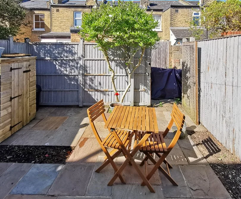 Plain paved courtyard with a wooden bistro table and chairs before garden redesign

The courtyard before its transformation, showing bare paving, a simple wooden bistro set and weathered fencing prior to the new planting and hard landscaping design.