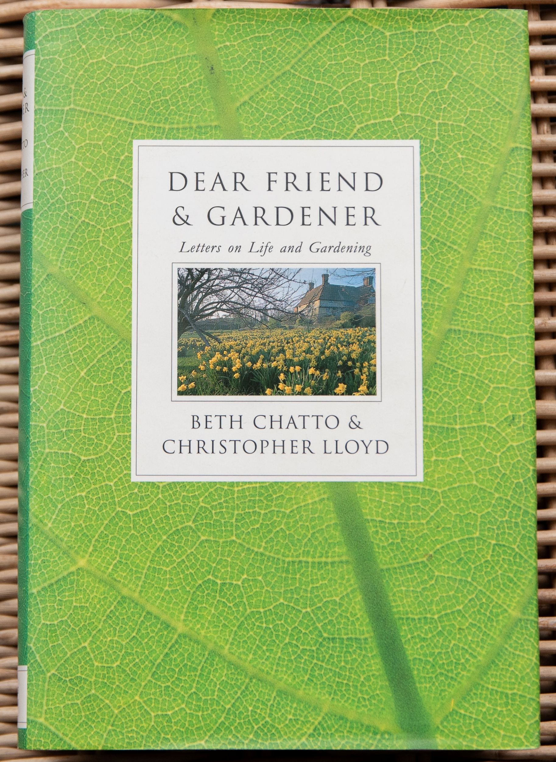 Book cover of Dear Friend & Gardener by Beth Chatto and Christopher Lloyd, set against a green leaf-vein background with an inset photo of daffodils.