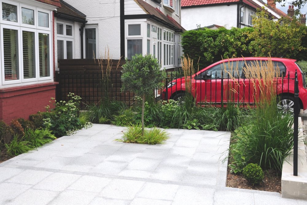 Granite paved driveway with olive tree and planting, Twickenham garden by Jane Shankster Garden Design

A pale granite driveway provides smart, practical parking space for two cars, softened by an olive tree and generous planting beds along its edges