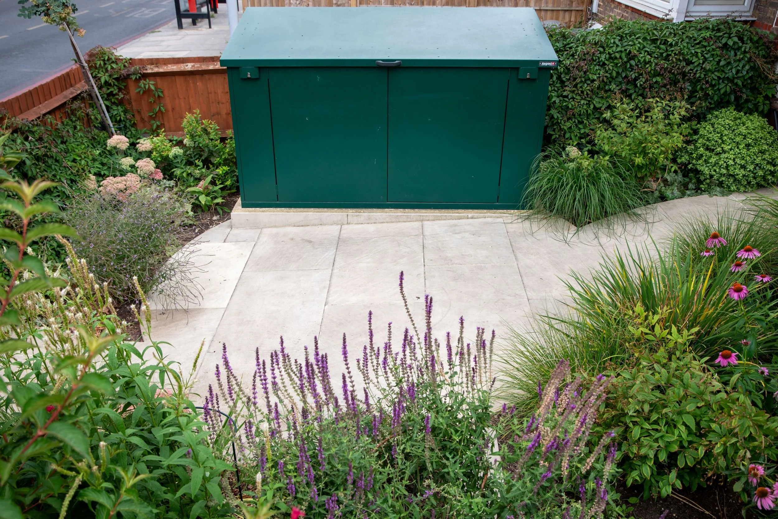 Green Asgard storage unit set on a new sandstone patio surrounded by planting. Designed by JaneShanksterGardenDesign.co.uk

The new green Asgard storage unit sits neatly on freshly laid sandstone paving, screened by ornamental grasses and echinacea p