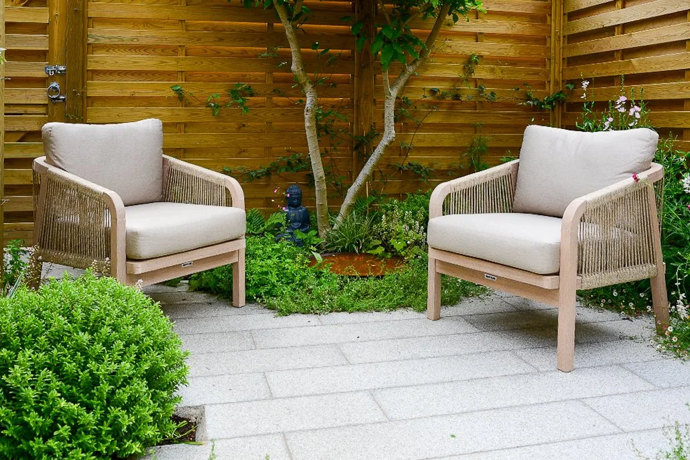 Two garden lounge chairs facing each other in a small courtyard with a Buddha statue and multi-stem tree

A pair of Kettler lounge chairs create an intimate seating area in this tiny Twickenham courtyard, centred around a multi-stem tree, Buddha stat