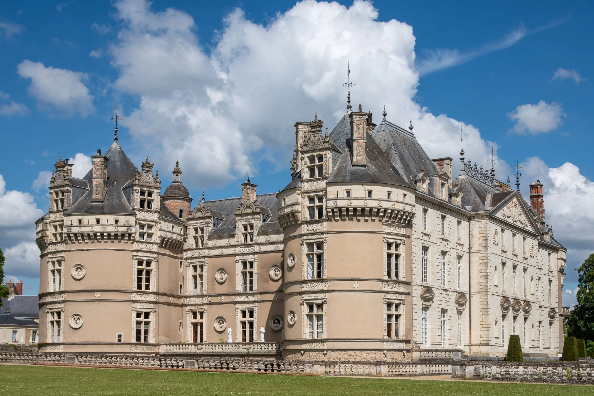 Ornate Renaissance facade of Château du Lude in the Loire Valley, with round corner turrets, dormer windows and a sweeping lawn in front.