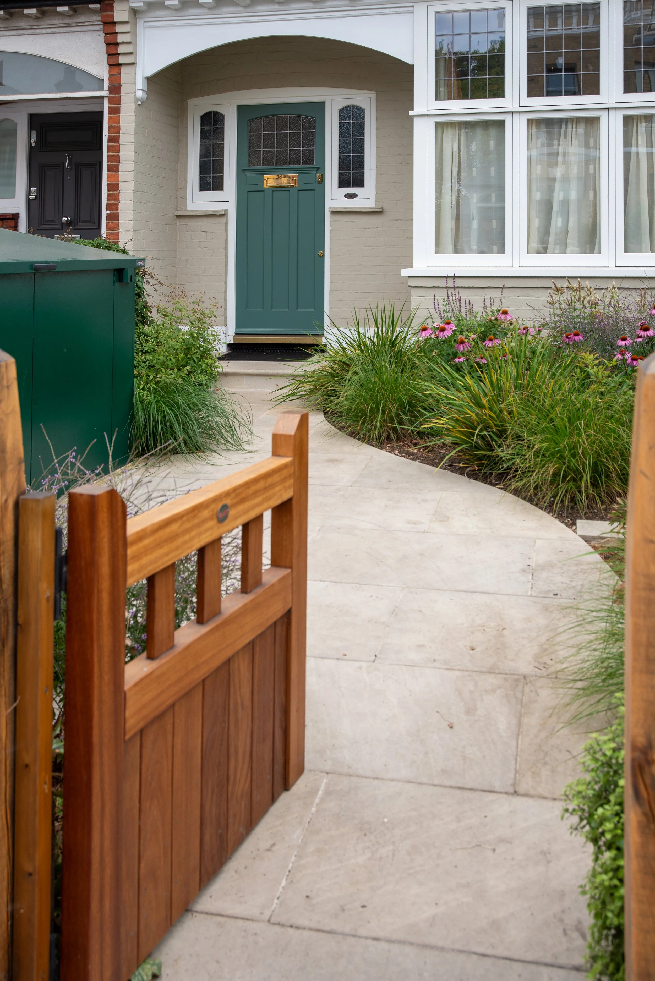 Row of Wandsworth terraced houses with a colourful front garden border of pink and purple flowers. Designed by JaneShanksterGardenDesign.co.uk

A wider view along the terrace showing the completed front garden's colourful mix of salvia, echinacea and