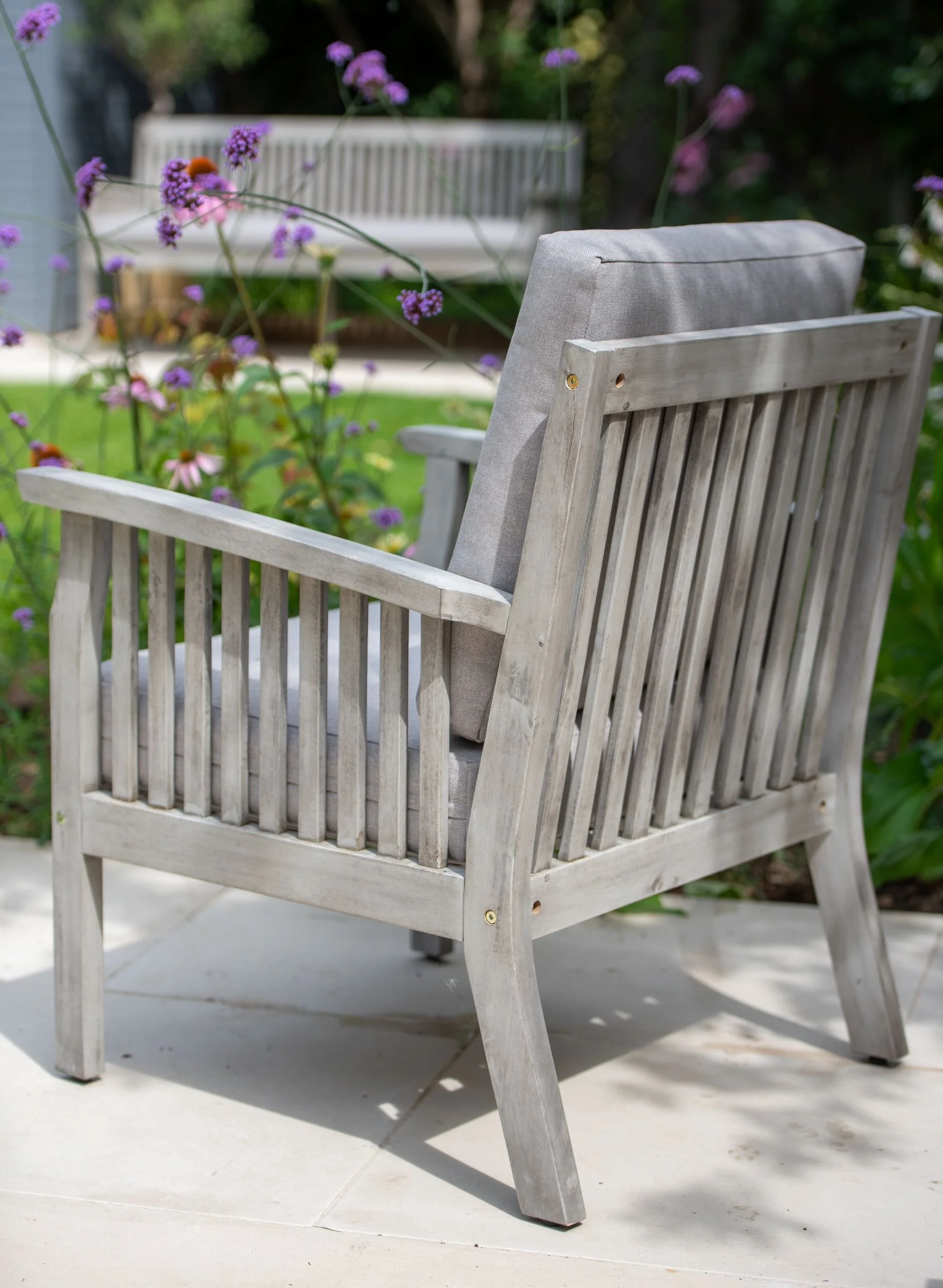 Close-up of a weathered wood garden armchair beside verbena bonariensis in a Wimbledon garden

A detail shot of a grey-washed wooden armchair on the terrace, with verbena bonariensis and echinacea flowering behind — part of the relaxed planting schem
