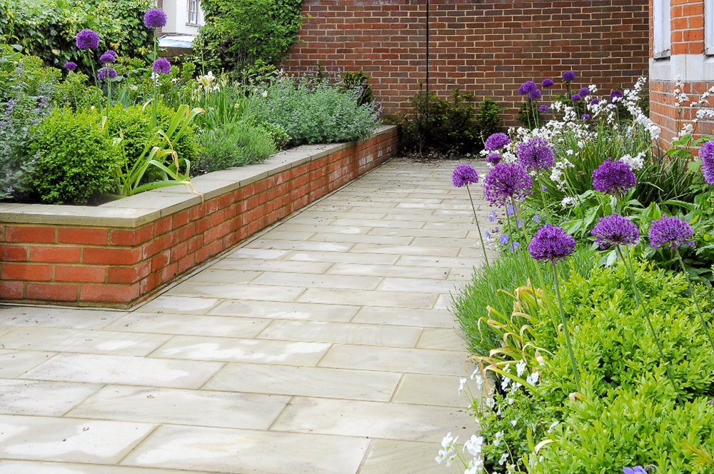 New sawn Yorkstone path and brick raised beds with alliums and iris after garden redesign

The same front garden after redesign: a clean sawn Yorkstone path flanked by brick-edged raised beds filled with alliums, iris and catmint — the finished schem