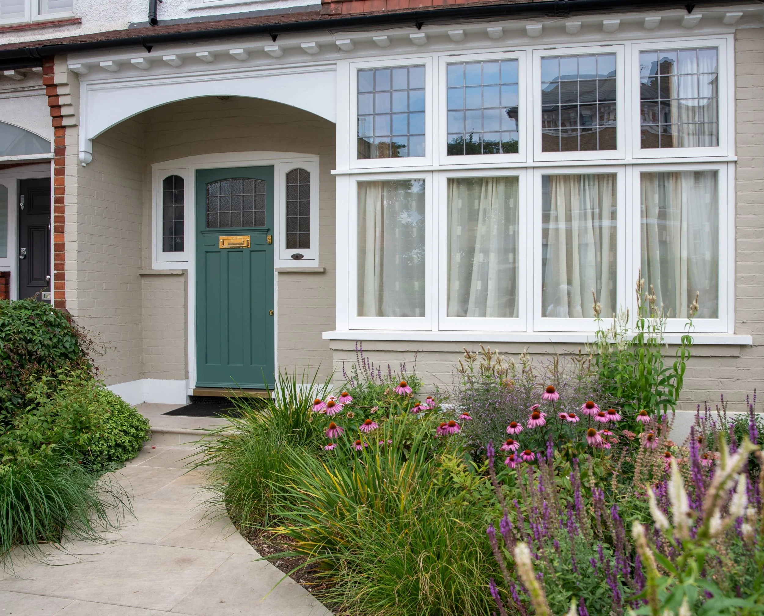 Green front door of a Wandsworth terraced house framed by echinacea and salvia planting. Designed by JaneShanksterGardenDesign.co.uk

The refurbished green front door and porch are framed by a lush border of echinacea, salvia and ornamental grasses a