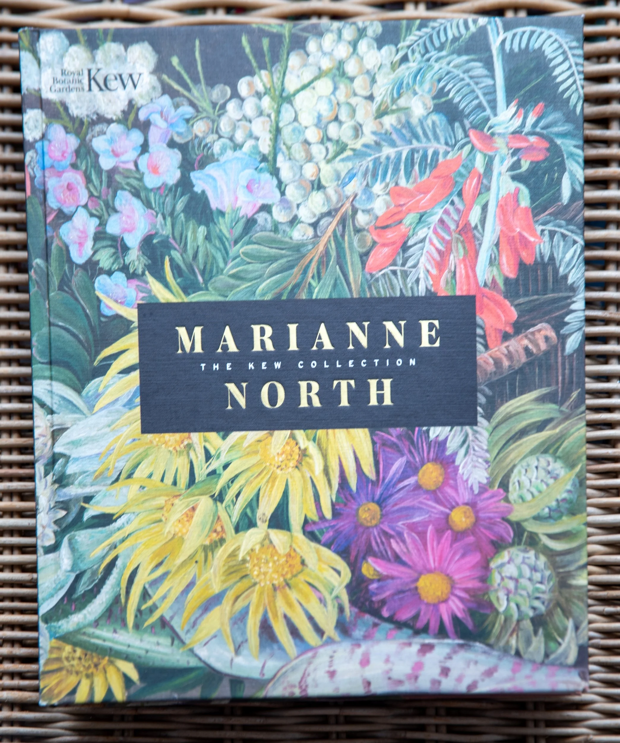 he book cover of 'Marianne North: The Kew Collection', featuring a colourful botanical painting of tropical flowers.