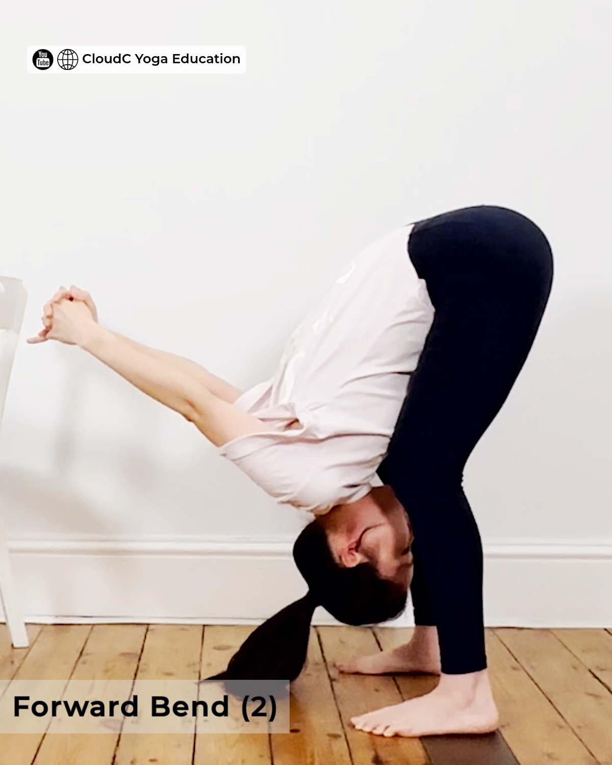 Woman in a standing forward bend with hands clasped and lifted behind her, yoga pose for back pain relief