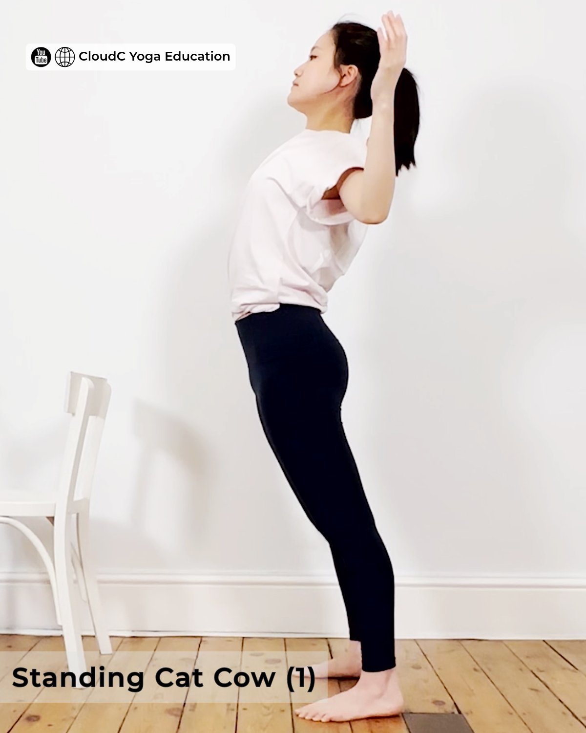 Woman practising standing cat cow, arms lifted back with chest open and gaze upward, beginner yoga pose for back pain