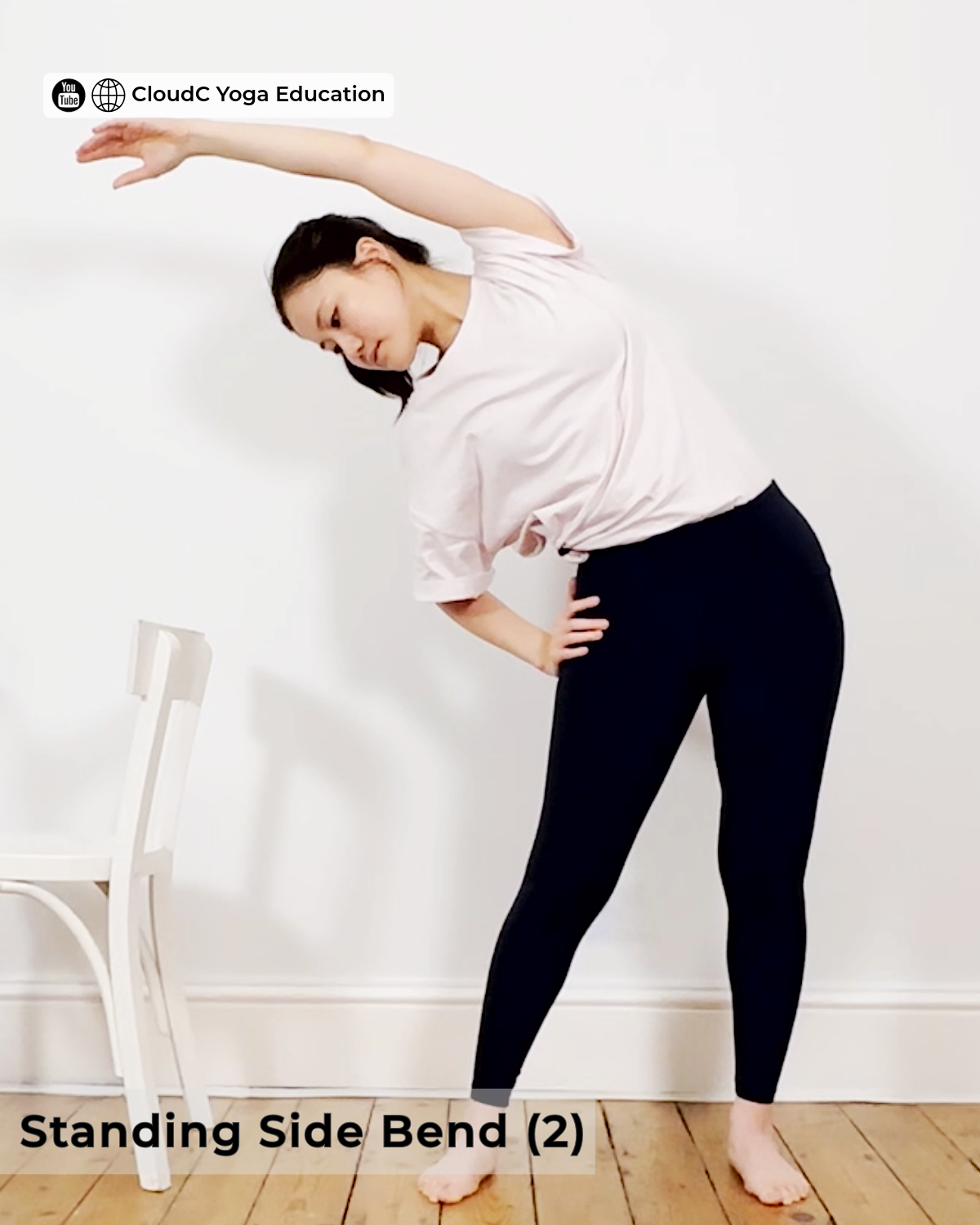 Woman in a standing side bend, left arm raised overhead, stretching the left side of the waist