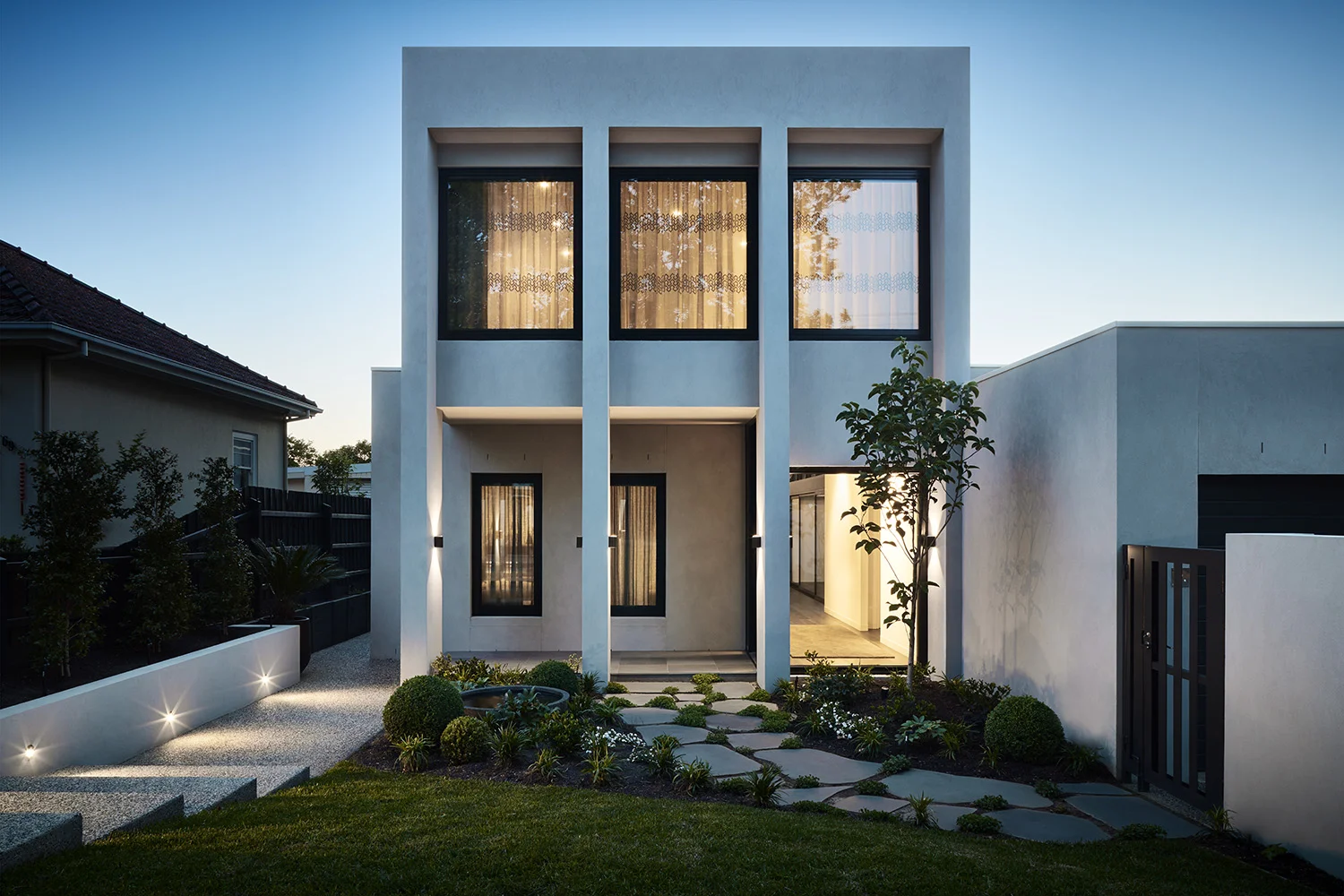 Wrestling with the challenges faced when building a new house on an E-W suburban block, McArthur presents a formal, rational face to the street which belies the central double-height glazed void and dynamic flow of spaces internally. Wrapping around a central courtyard, the void orders the planning and draws light into the centre of the house.