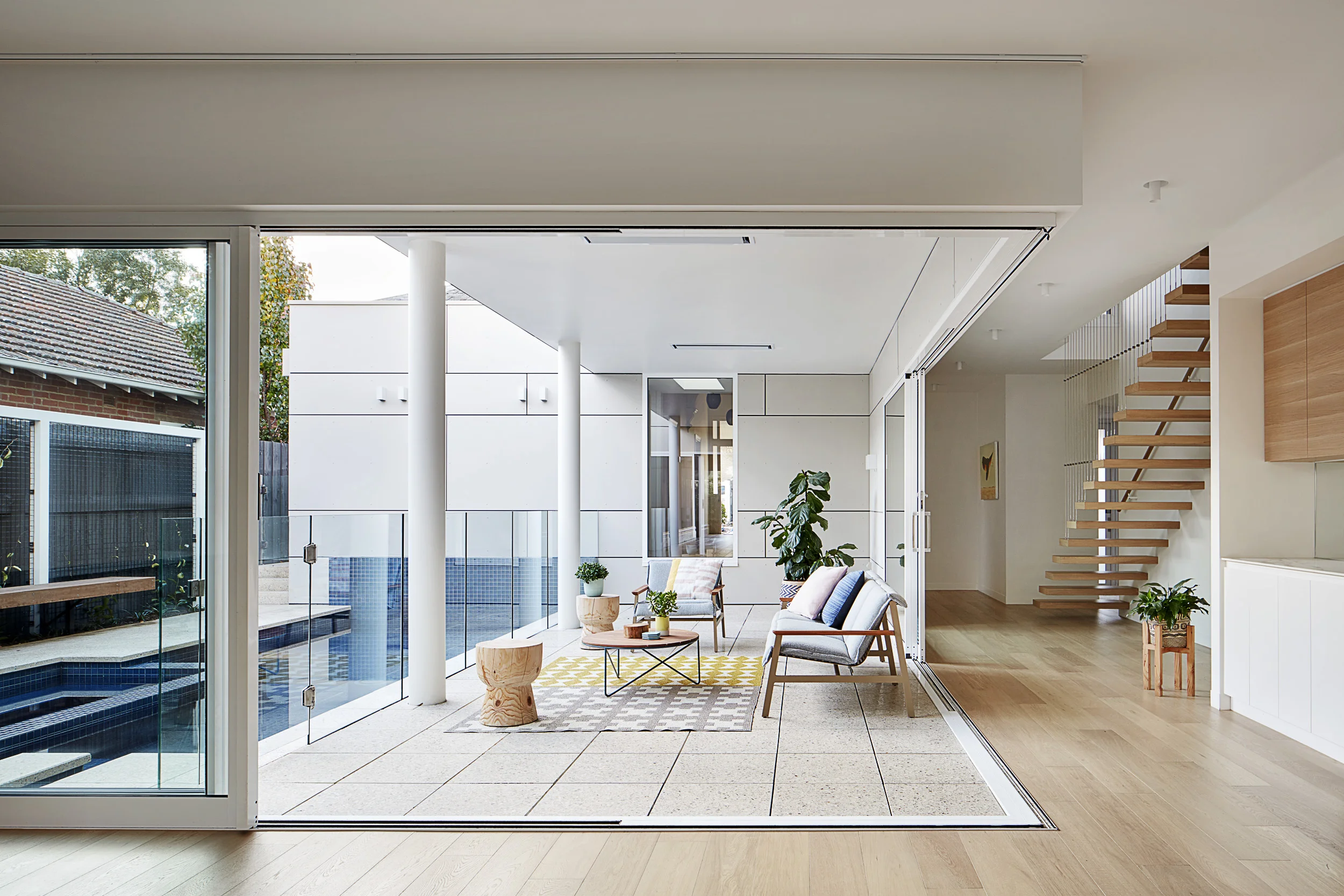 A 2-storey, contemporary addition was added to an existing, double-fronted, free-standing Victorian house. Given the site’s southern orientation, a C-shaped plan was developed to maximise sun and natural light. The ground floor has been shaped around a central courtyard containing outdoor living and pool and spa. The house is filled with sun throughout the year and a palette of light, airy materials create a feeling of light and space.
