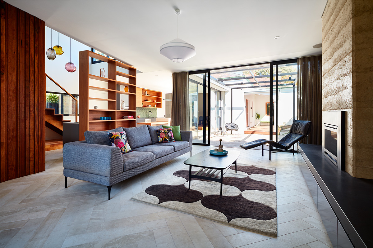 ‘Grasmere’, is an early Victorian House in Melbourne which has undergone a major transformation. A central courtyard and kitchen creates a link to a new 2-storey addition carefully designed around a 100 year old mulberry tree. The owner’s interest in art and design drove the brief and called for a warm, textured palette with rich colour and pattern. As part of an enduring selection of materials, structural rammed earth is a key element that will patina alongside its masonry Victorian counterpart for many years to come.