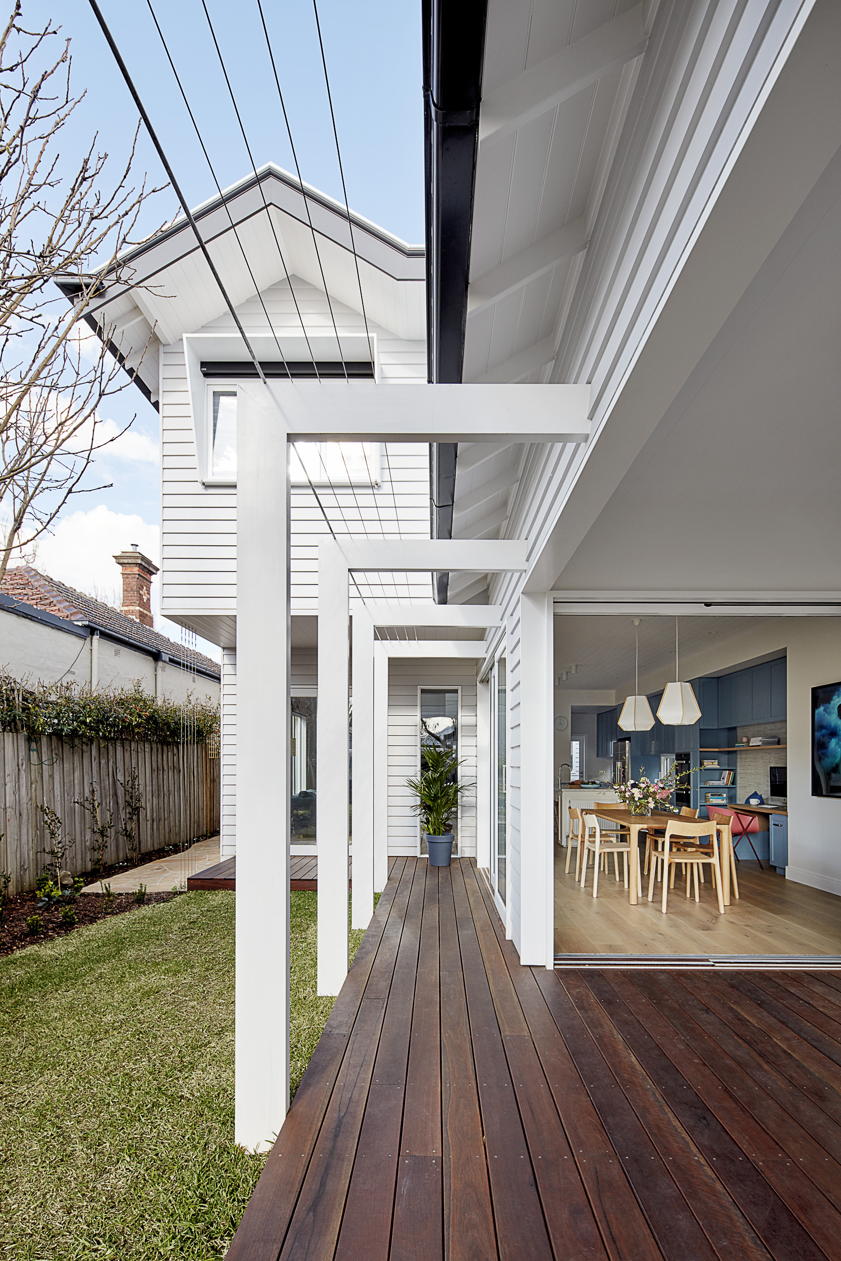 Large L-shaped pergola beams demarcate the edge of the decking and will overtime support greenery to grow over the pergola.