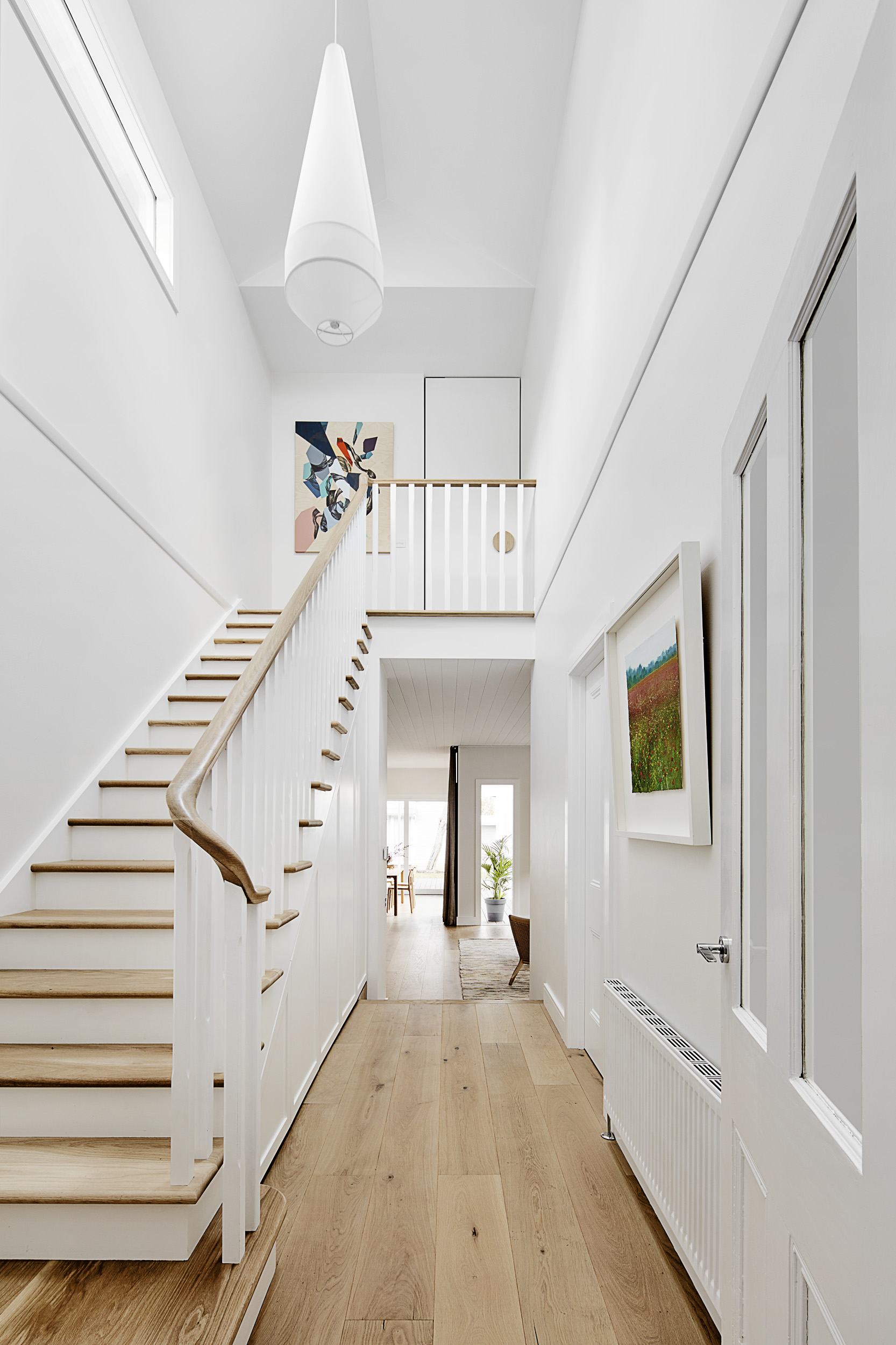 Beyond the original hall you arrive in a generous void space with a hand-crafted Oak stair case, a highlight window and skylight bring natural light into the middle of the house. Lighting: Coco Flip Pendant - Cult Flooring: European White Oak Timb