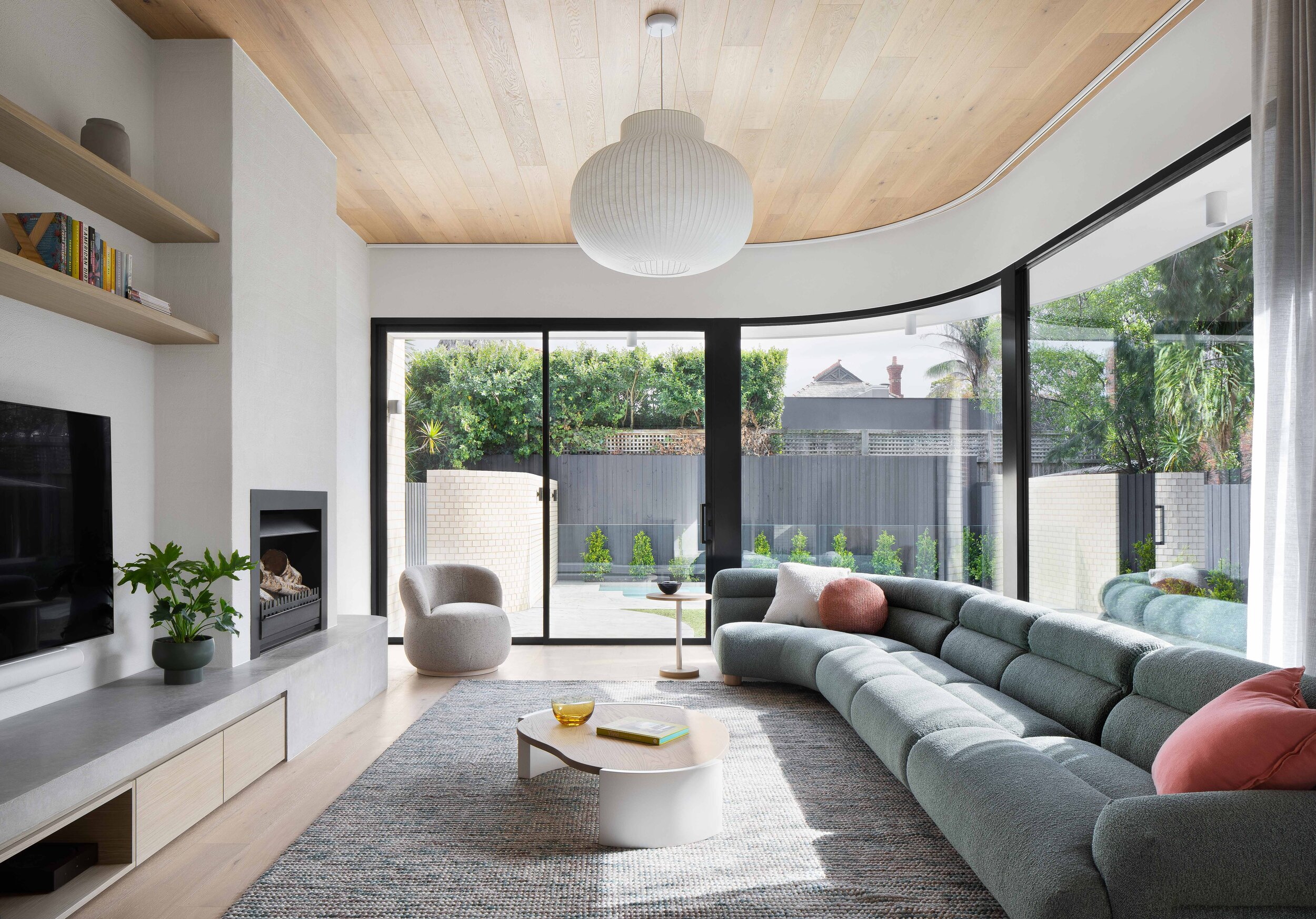 Integrated cabinetry and a minimal palette of materials create a seamless style that is utterly connected to the tree and garden.
