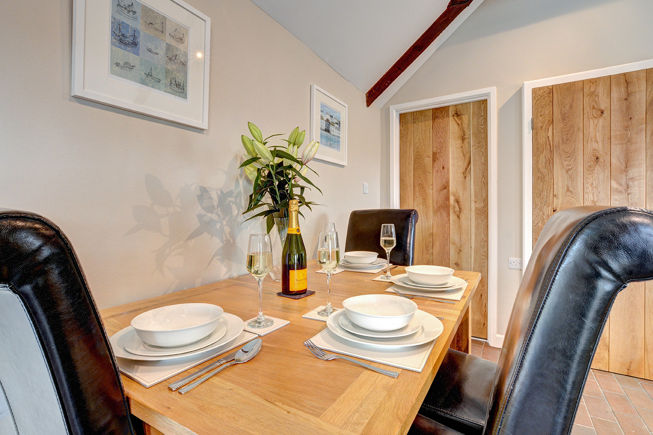 The dining area of Otterbridge luxury self catering converted barn holiday cottage at Penrose Burden in North Cornwall01.jpg