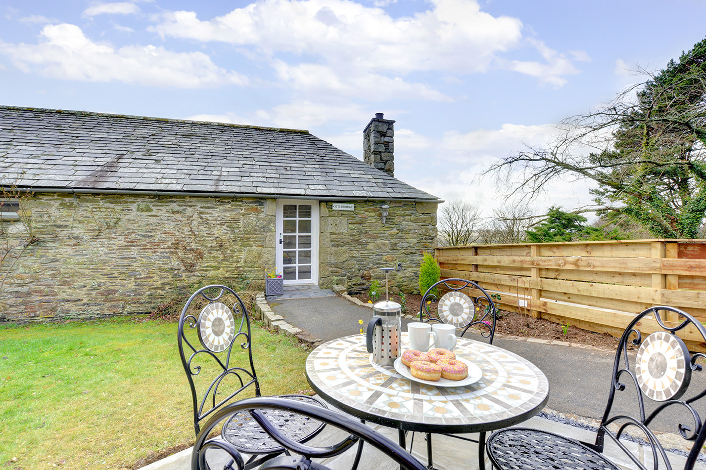 The patio and garden area outside of Otterbridge luxury self catering converted barn holiday cottage at Penrose Burden in North Cornwall.jpg
