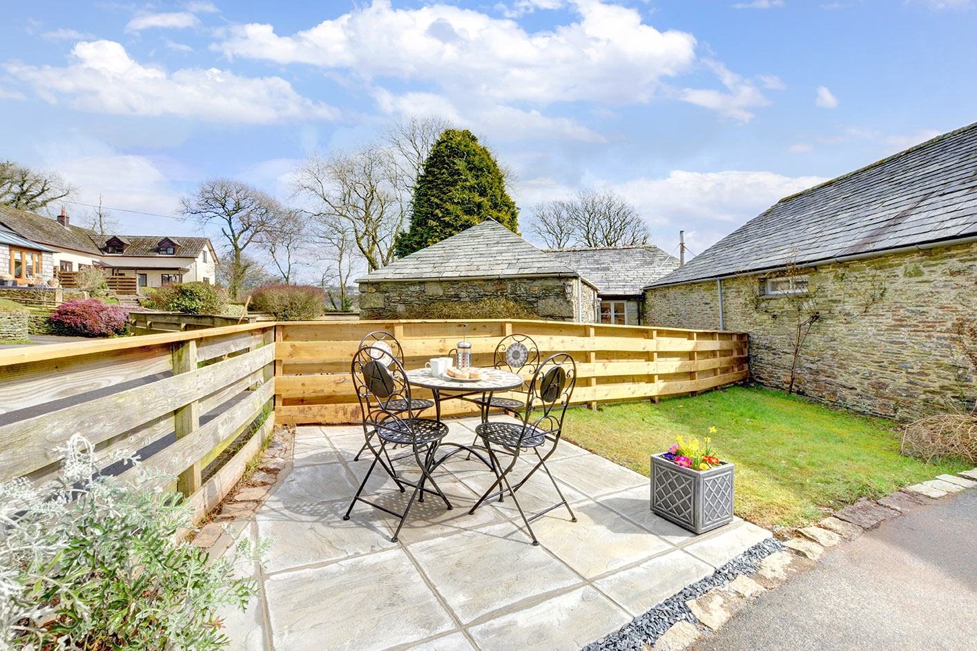 The patio and garden area outside of Otterbridge luxury self catering converted barn holiday cottage at Penrose Burden in North Cornwall01.jpg