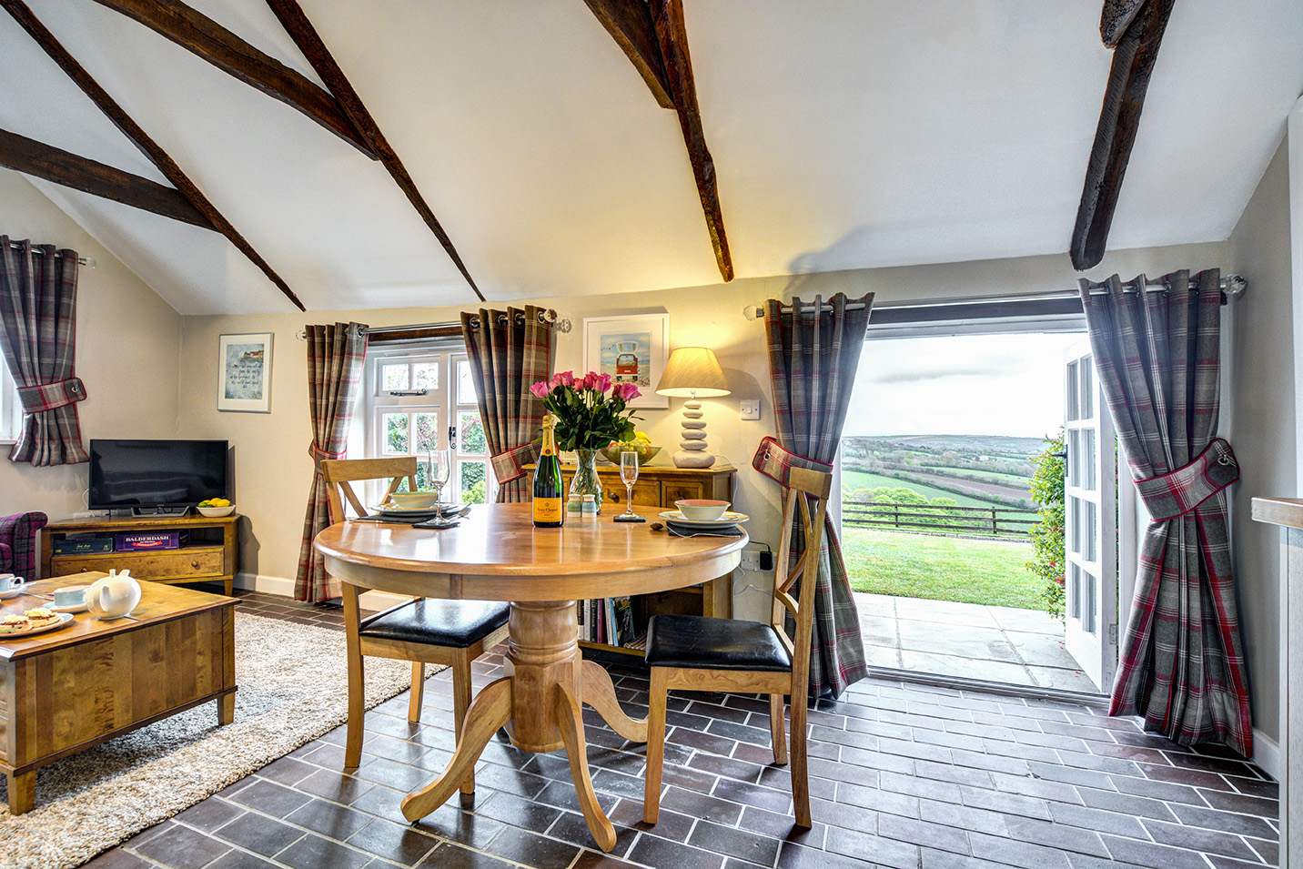 The lounge and dining area looking out the patio doors of The Linney self catering cottage converted barn at Penrose Burden holiday cottages in Cornwall.jpg