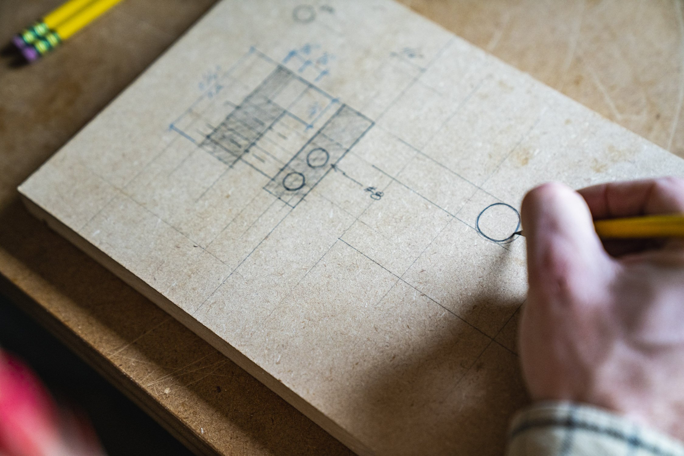 Environmental Portrait of Casey Chandler designing a wooden latch in Santa Cruz, CA