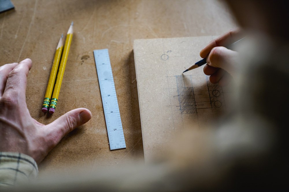 Environmental Portrait of Casey Chandler designing a wooden latch in Santa Cruz, CA
