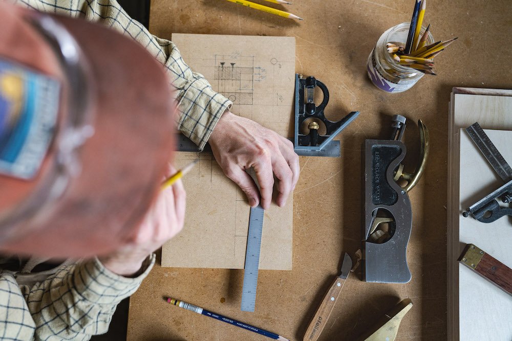 Environmental Portrait of Casey Chandler designing a wooden latch in Santa Cruz, CA
