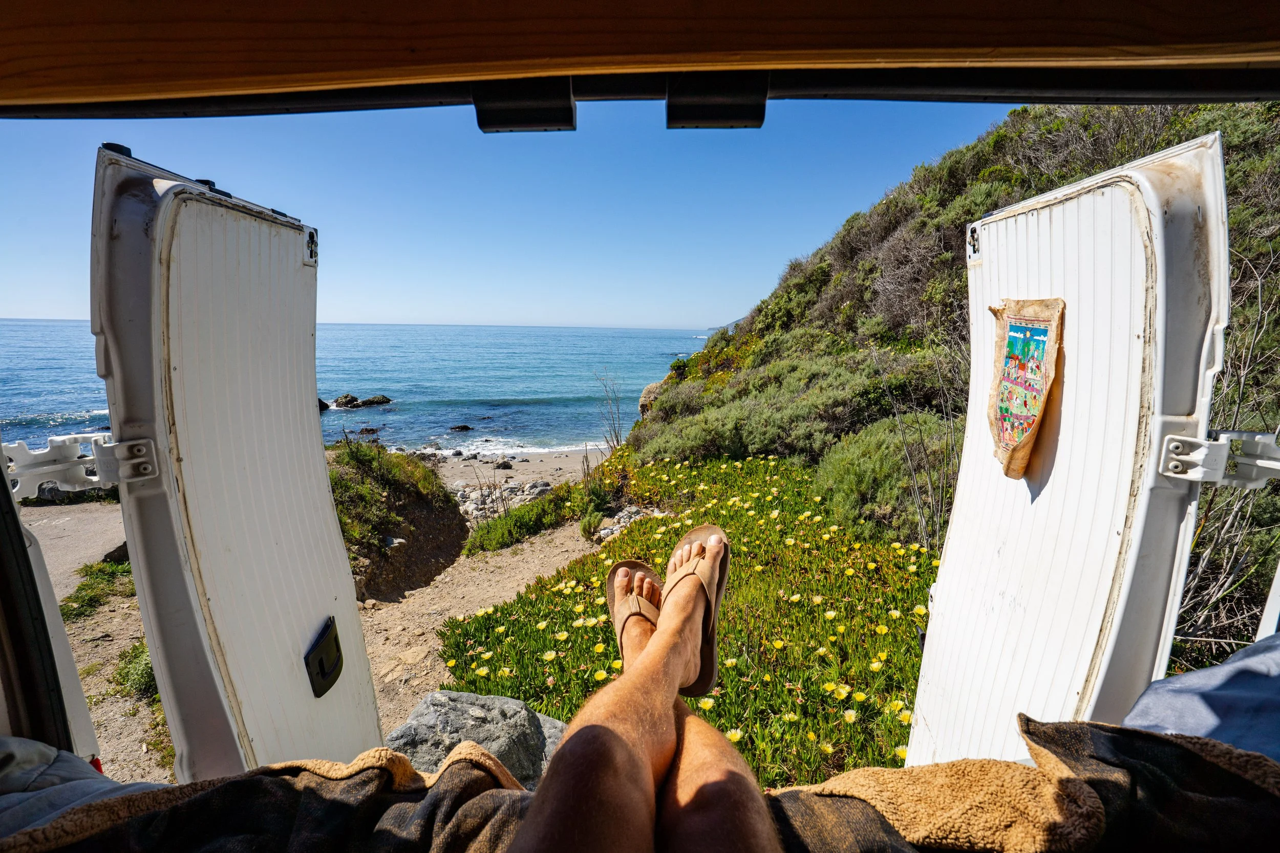 Outdoor photographer, Dalton Johnson, snaps a photograph out the back of his van looking at Mill Creek and the Pacific Ocean in Big Sur, CA