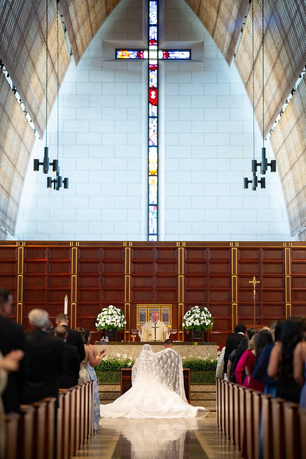 Wide view of the church sanctuary with a large cross over the altar and Rachel's long veil spread across the floor